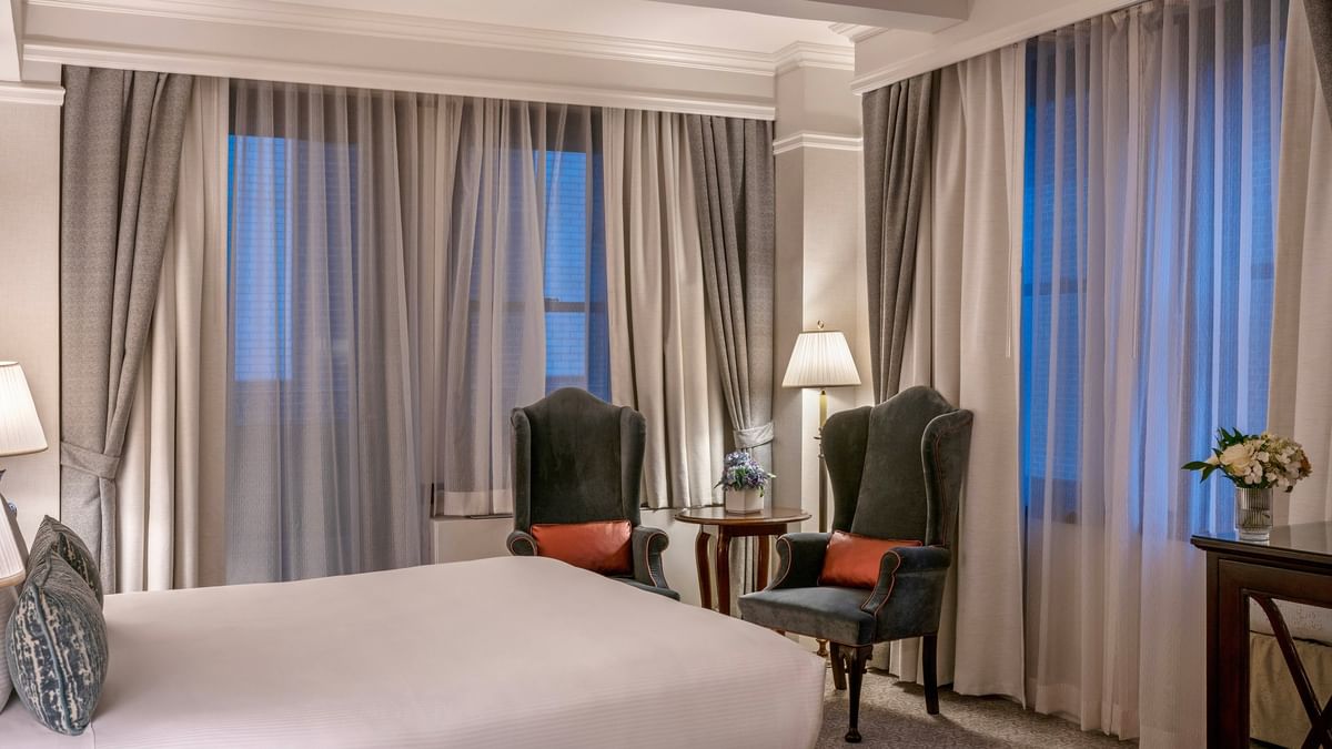 Elegant 54th Suite with a large bed and a couch by the window at Warwick New York