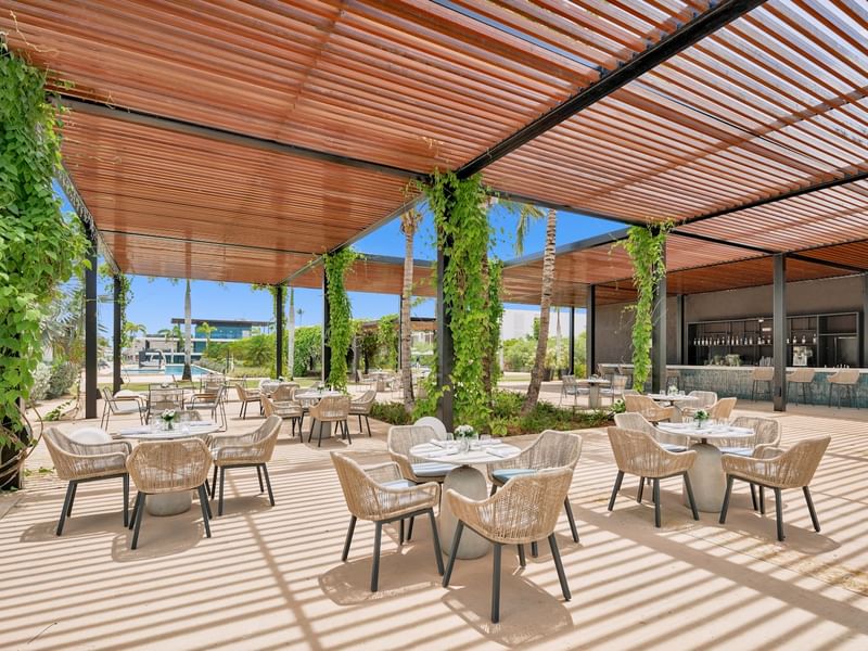 Dining tables set up under a pergola in Wonderpool at Live Aqua Resorts and Residence Club