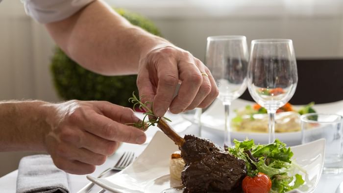 Close up on a dish garnishing by a chef at Hotel Eclipse