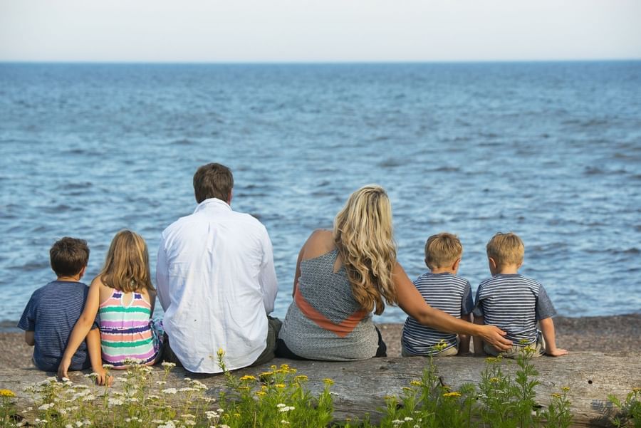 Family sitting by the beach near Lutsen Resort