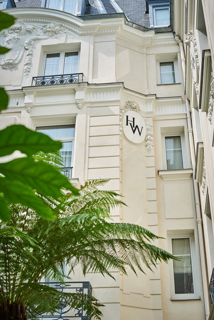 Façade haussmannienne en pierre claire avec ornements sculptés et balcon en fer forgé à Hotel Westminster Warwick Paris