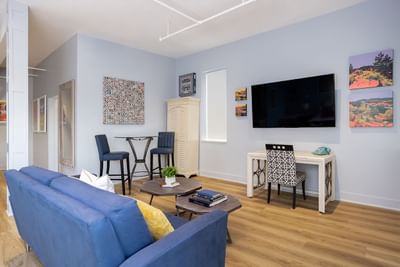 TV lounge area with cozy sofa & working table in King Premiere at Retro Suites Hotel