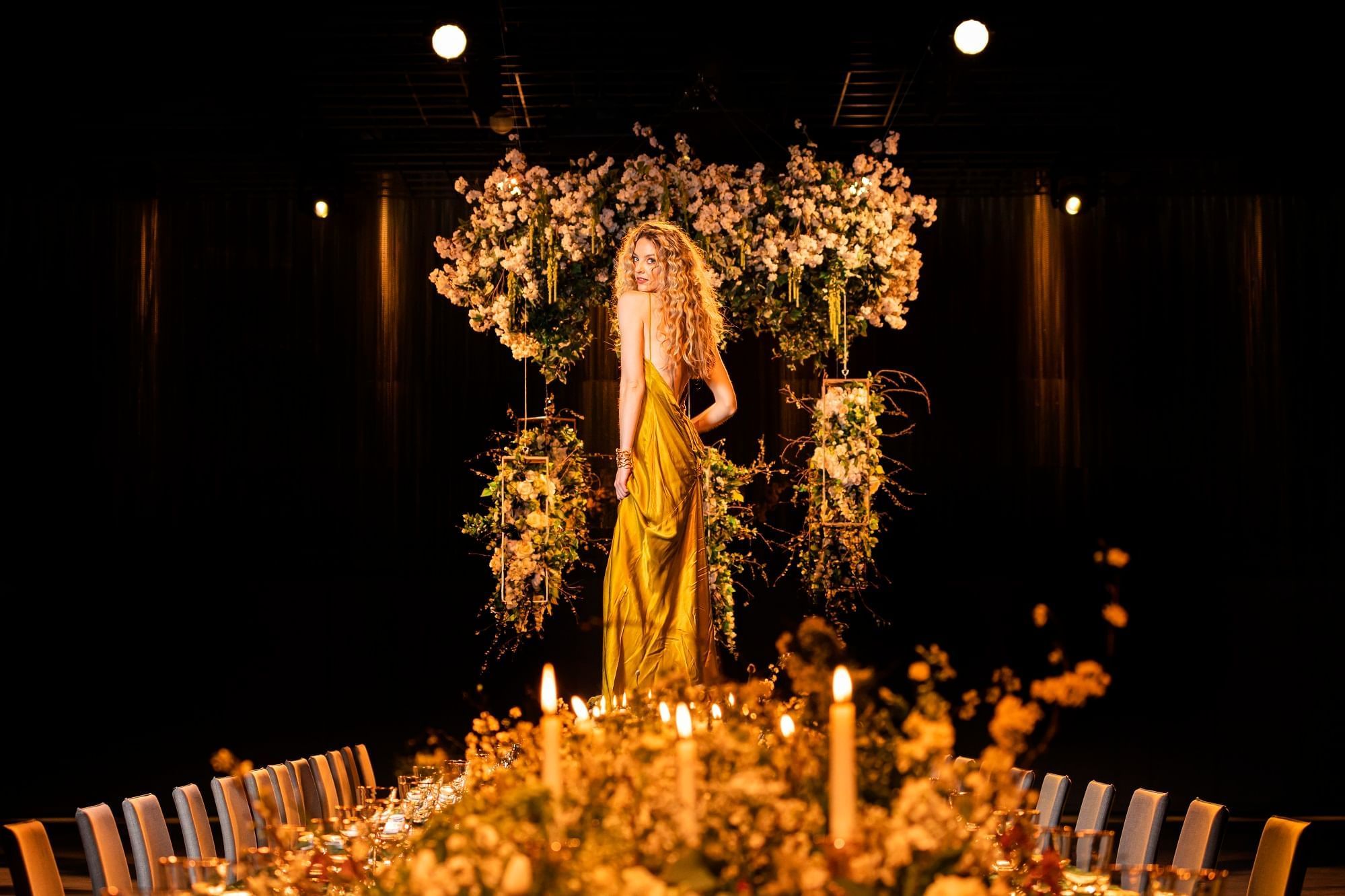 A yellow-dressed lady in a model poses on the decor table at The Londoner Hotel