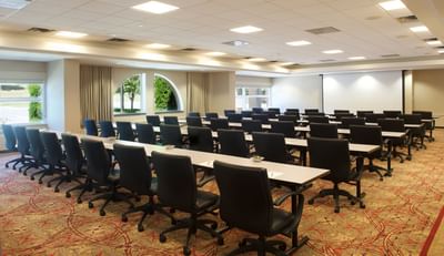 A spacious conference room at the Bolger Center is arranged with long tables and chairs for a meeting