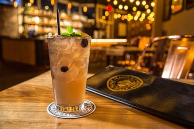 a mixed drink and a bar menu