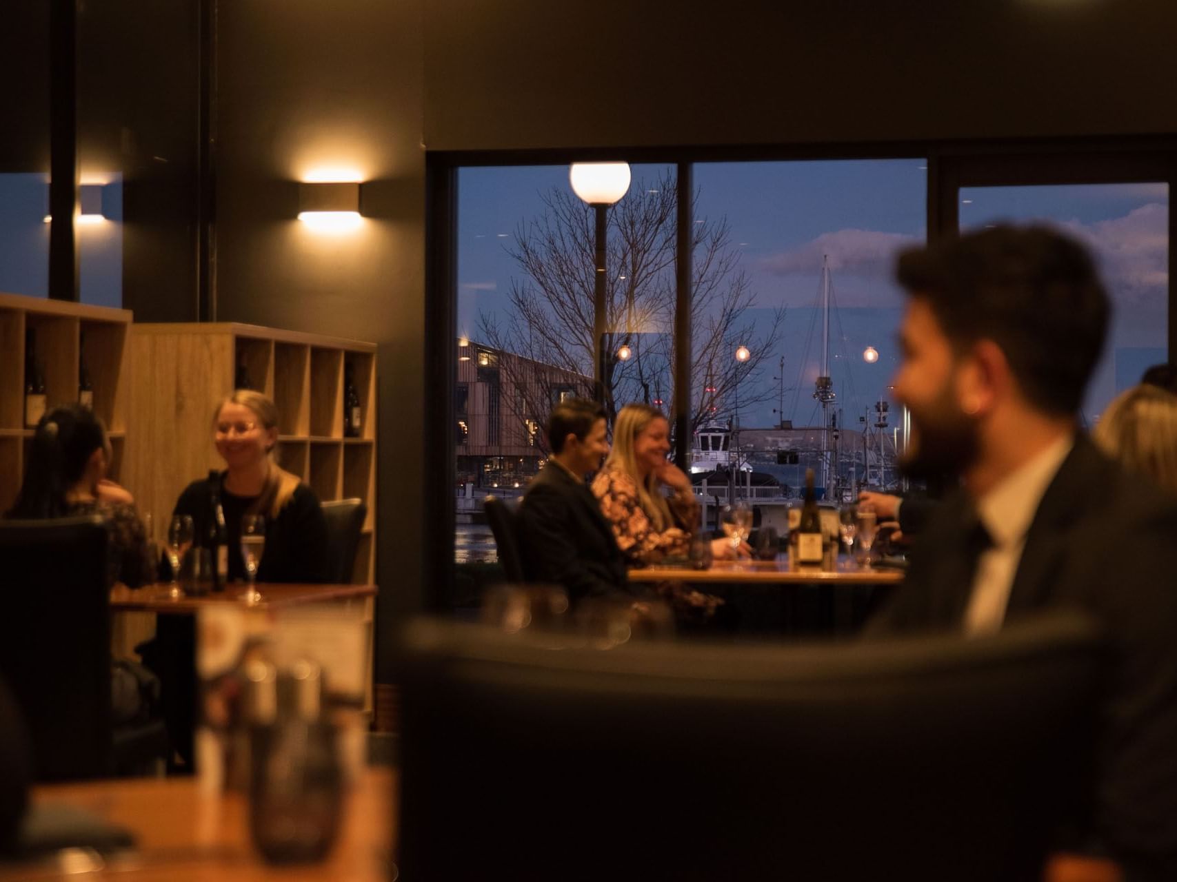 Guests having dinner in Tasman Restaurant with Hobart dock view at Hotel Grand Chancellor Hobart