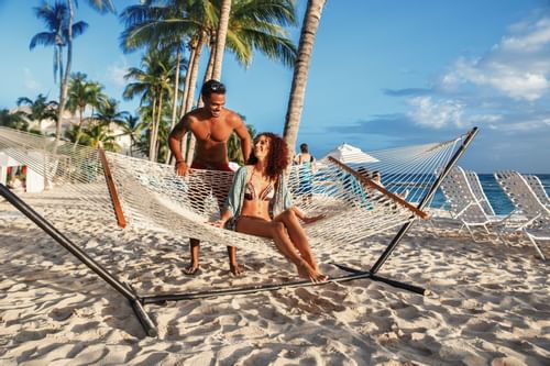 Couple spending time on a hammock by the beach at Sugar Bay