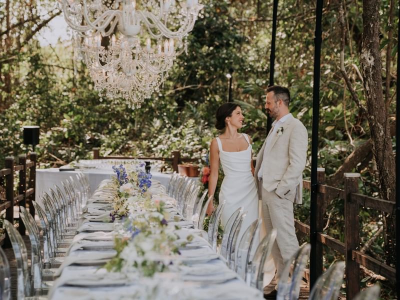 Couple standing by table set-up & chairs in  Four Mile Beach at Pullman Port Douglas