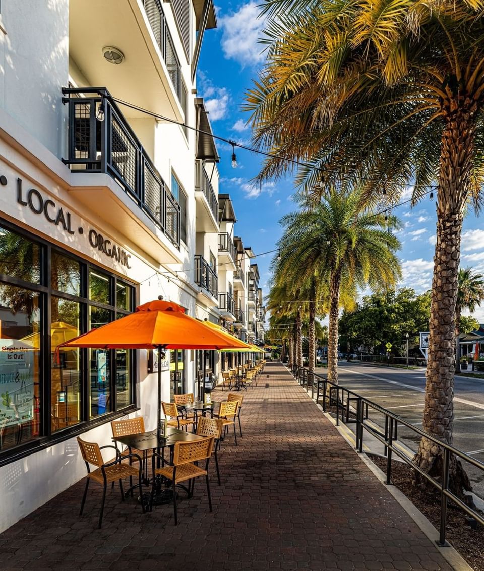 Outdoor dining setup with tables and chairs on the sidewalk near Grant Street Inn in Dunedin FL