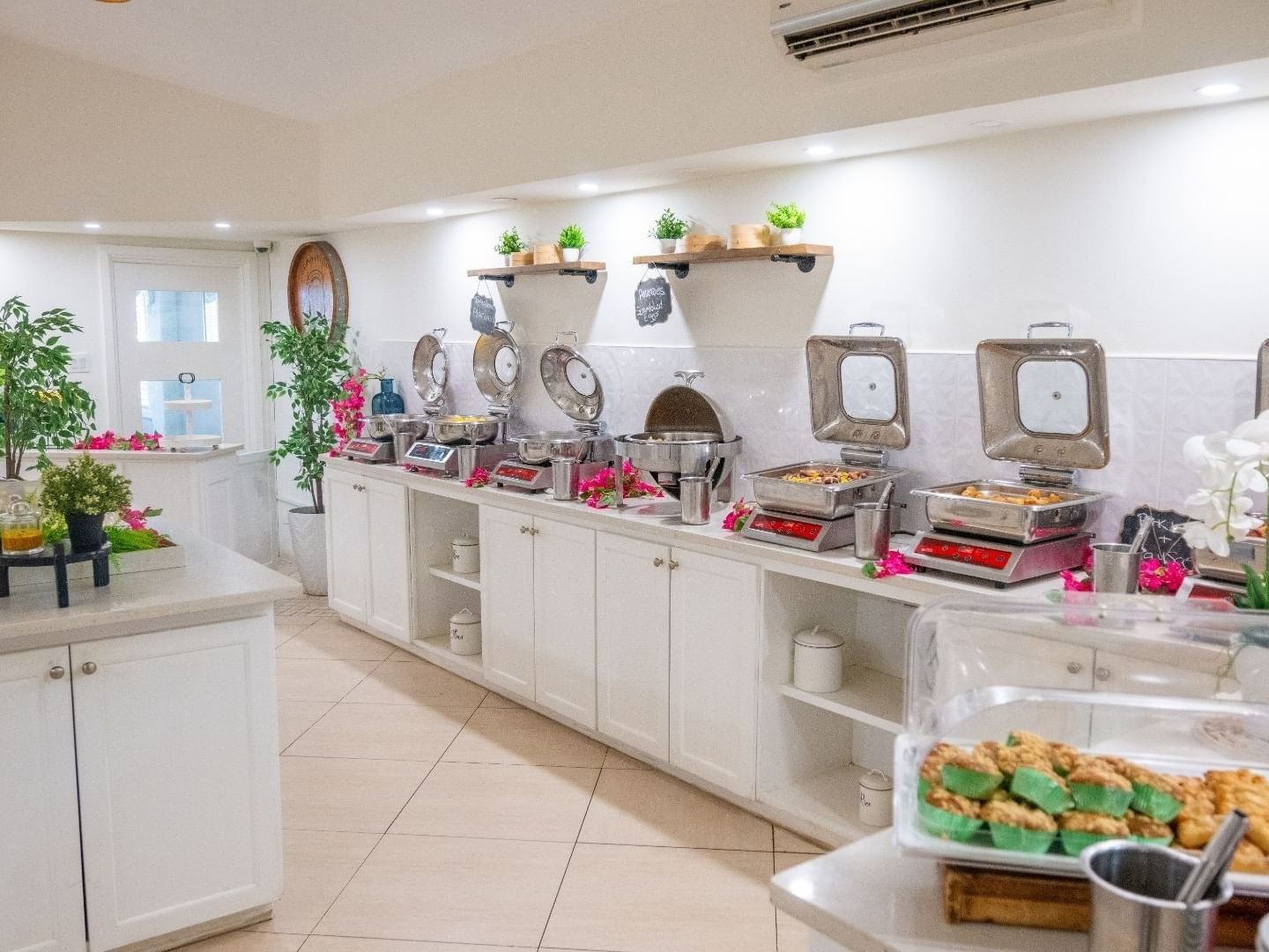 Buffet area with multiple food stations and floral decorations at Savannah Beach Hotel.