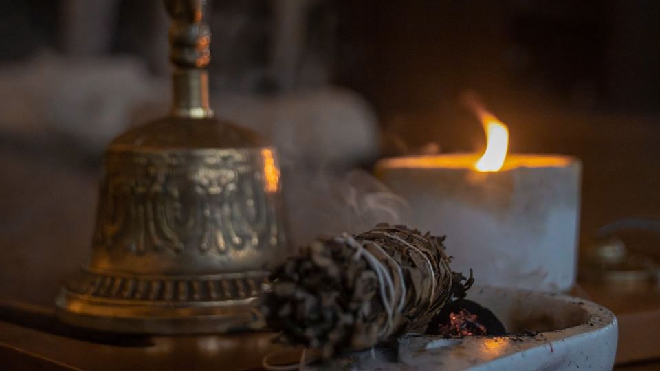 Smoldering sage bundle with a bell and lit candle in Wellness Center at El Silencio Lodge & Spa