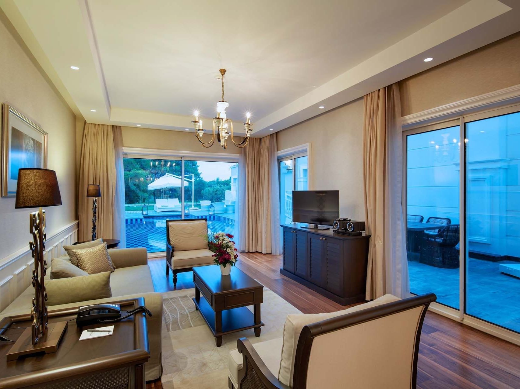 TV lounge area in Design Pool Villa with wooden floors at Titanic Deluxe Golf Belek