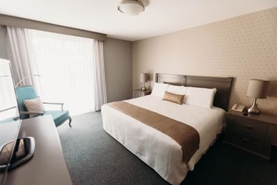 Large bed, nightstand & chair in Suite at Araiza Mexicali