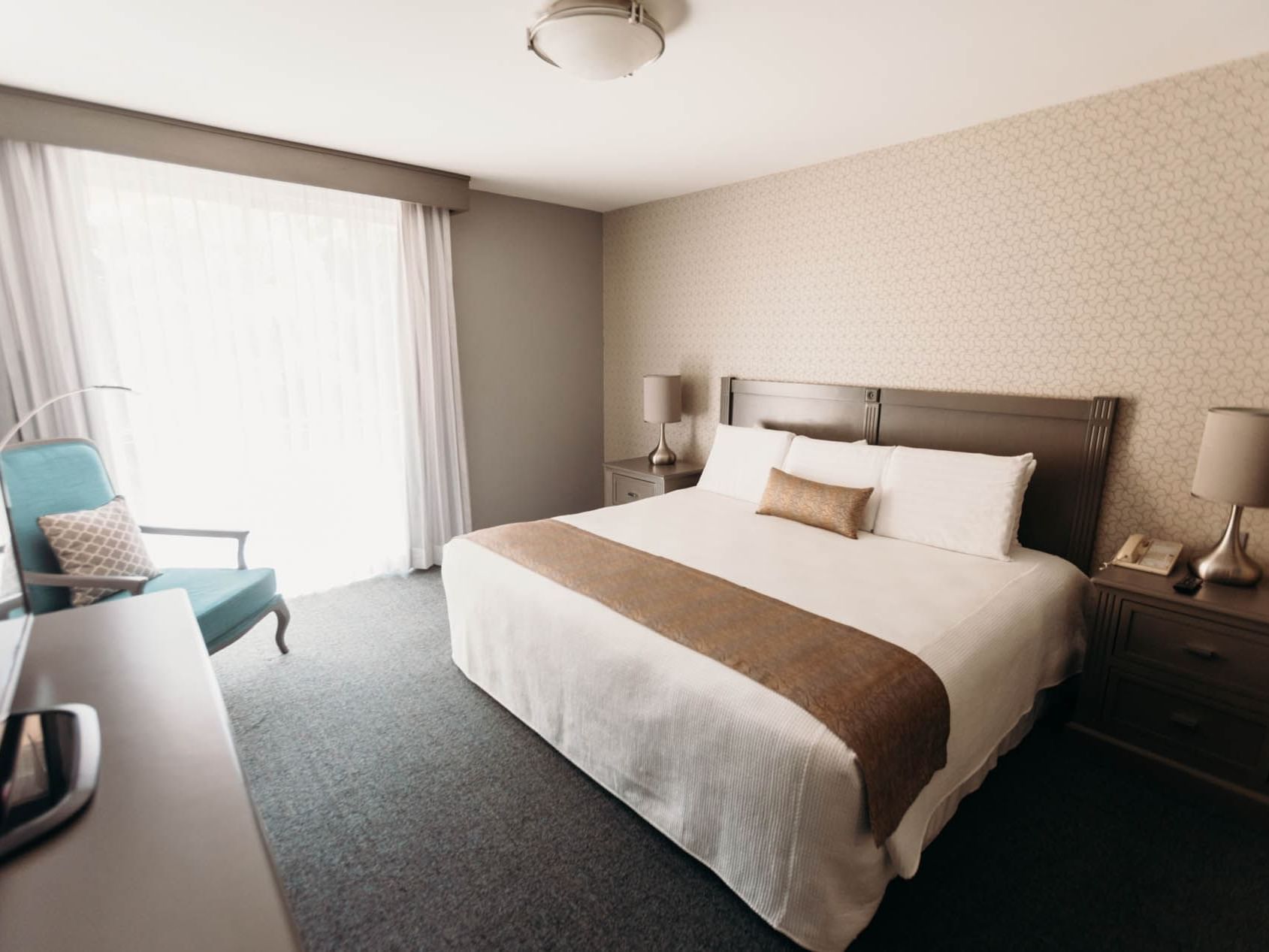 Large bed, nightstand & chair in Suite at Araiza Mexicali