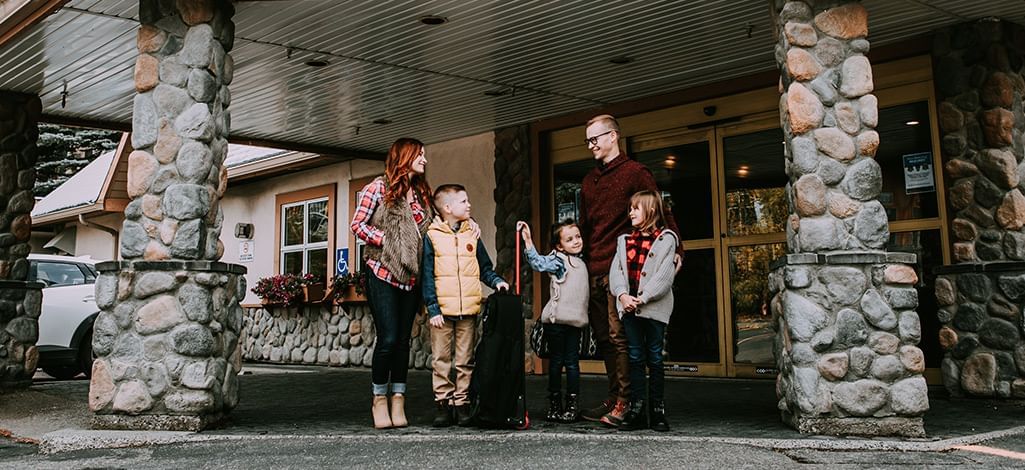 Family standing outside of Coast Canmore Hotel in Alberta