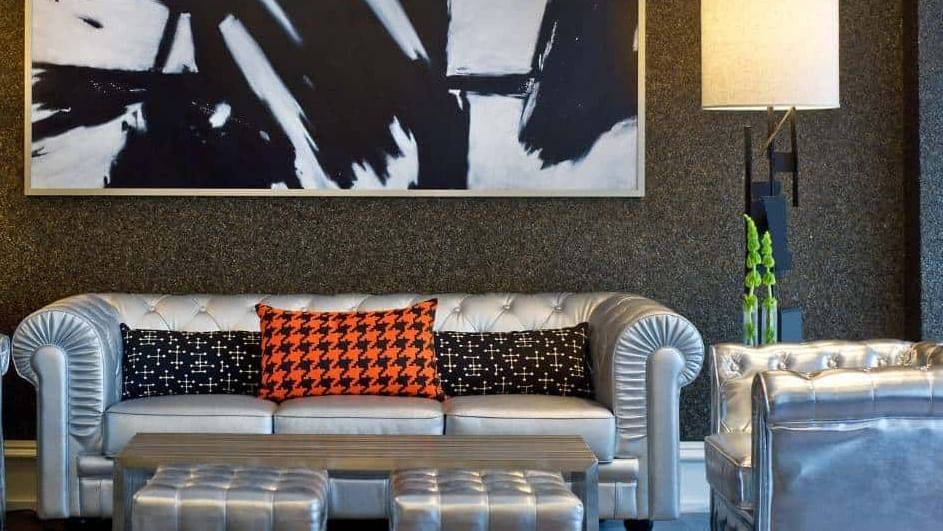 A stylish lobby lounge with a leather sofa, coffee table, and modern lighting.