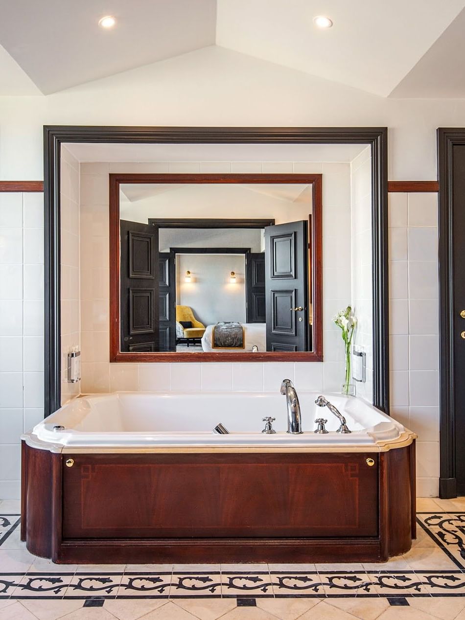 Luxe badkamer met groot bad en spiegel in de Barsey Suite bij Hotel Barsey by Warwick in Brussel.