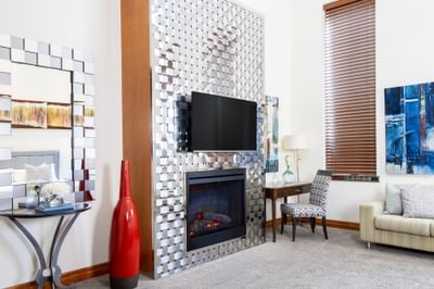 Living area with TV, fireplace & comfy sofa in King Superior Manhattan at Retro Suites Hotel