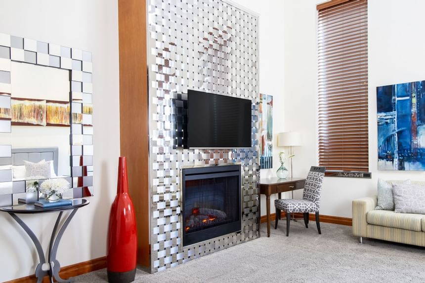 Living area with TV, fireplace & comfy sofa in King Superior Manhattan at Retro Suites Hotel