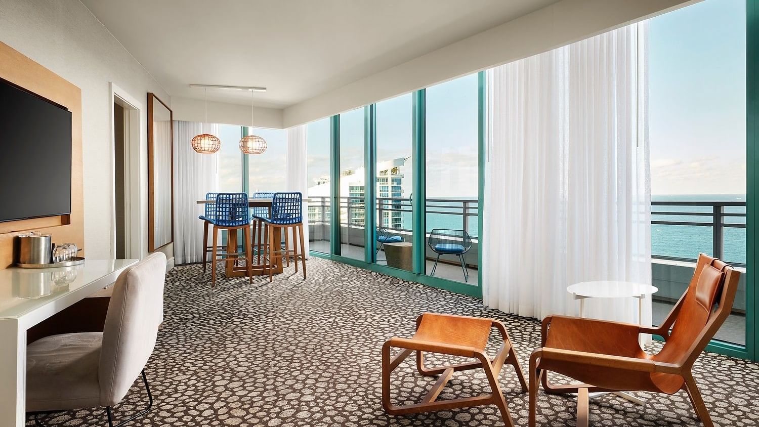 Oceanfront guest room with floor-to-ceiling windows and private balcony.