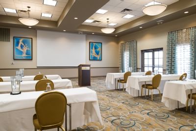 tables and chairs facing a projector screen