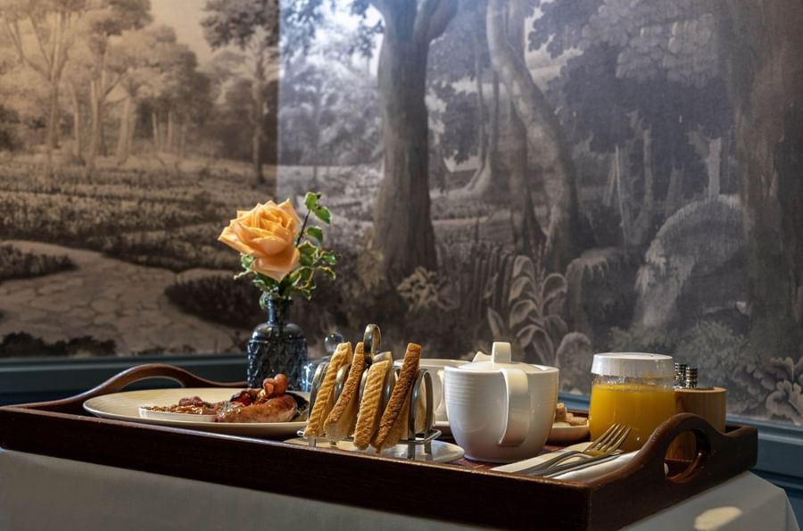 Breakfast tray set with rose vase, under a mural wall at The Capital Hotel, Apartments and Townhouse