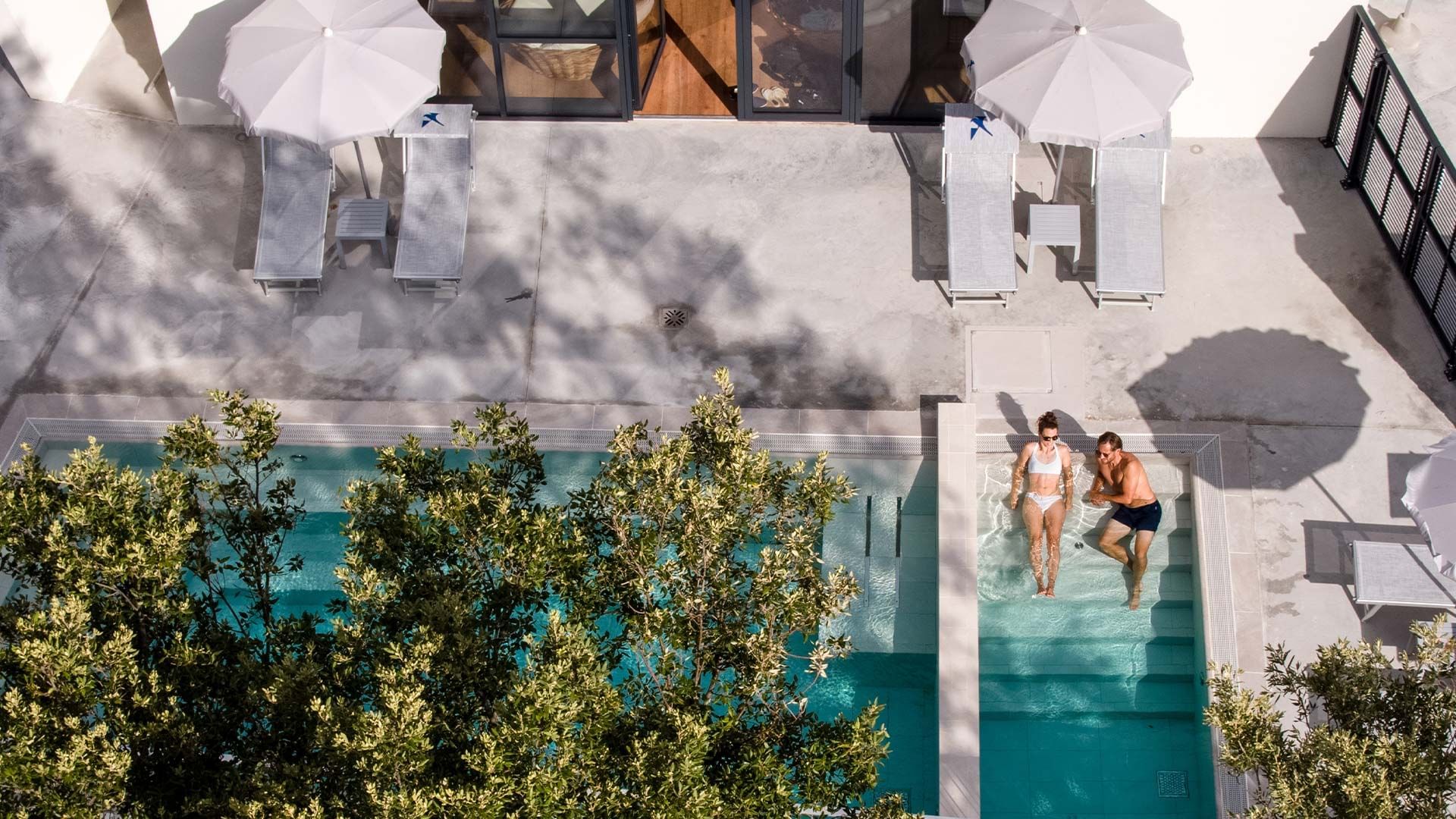 Aerial view of a couple relaxing in the outdoor pool area at Falkensteiner Premium Camping Zadar