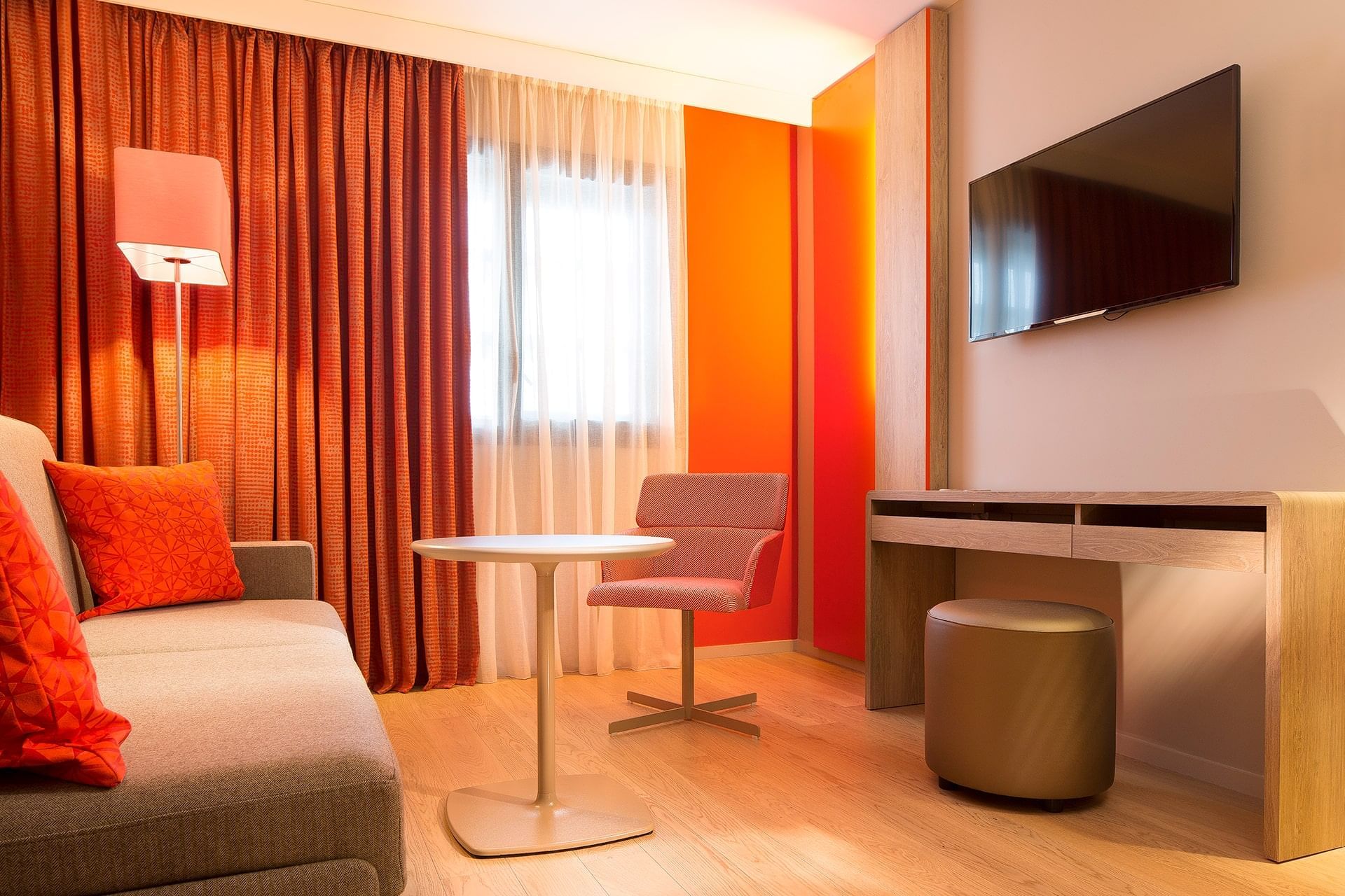 Coin salon avec TV dans une Suite à l'Oceania Paris Roissy CDG