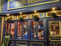 The Bebop restaurant's blue facade with lit windows, potted plants, and a chalkboard sign outside.