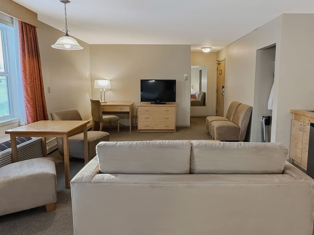 hotel room sitting area with sofa bed and mini fridge