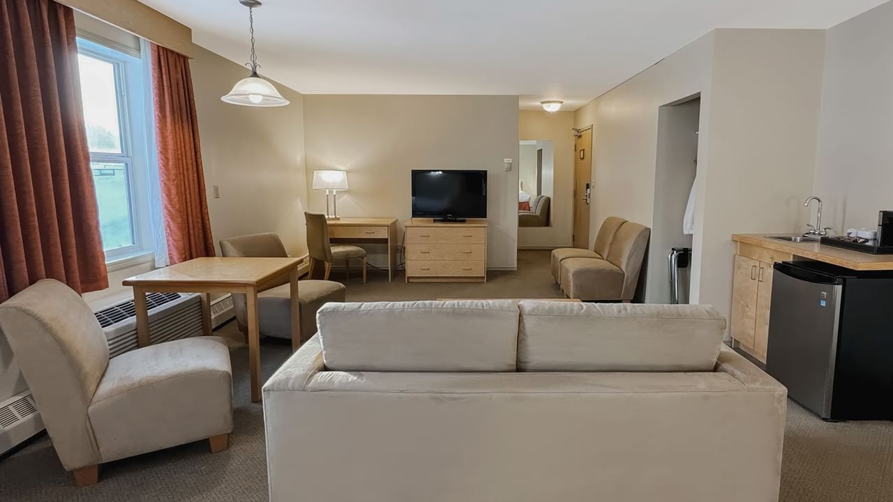 hotel room sitting area with sofa bed and mini fridge