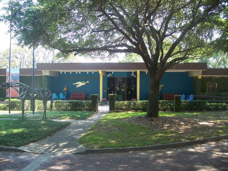 A blue and yellow building with a tree in front of it.