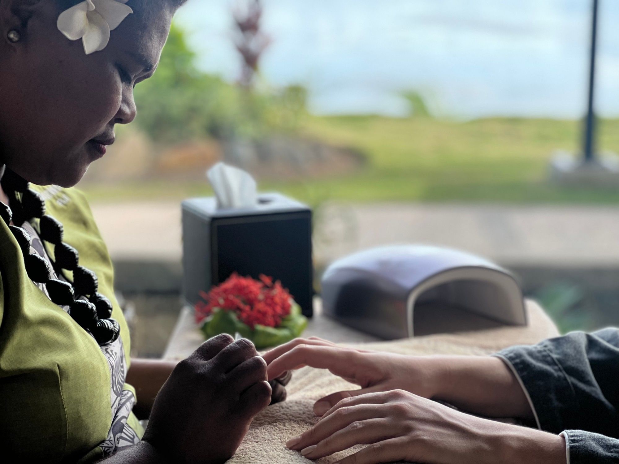 Woman performing manicure on another person's hands at Warwick Fiji Resort and Spa - Redesign.