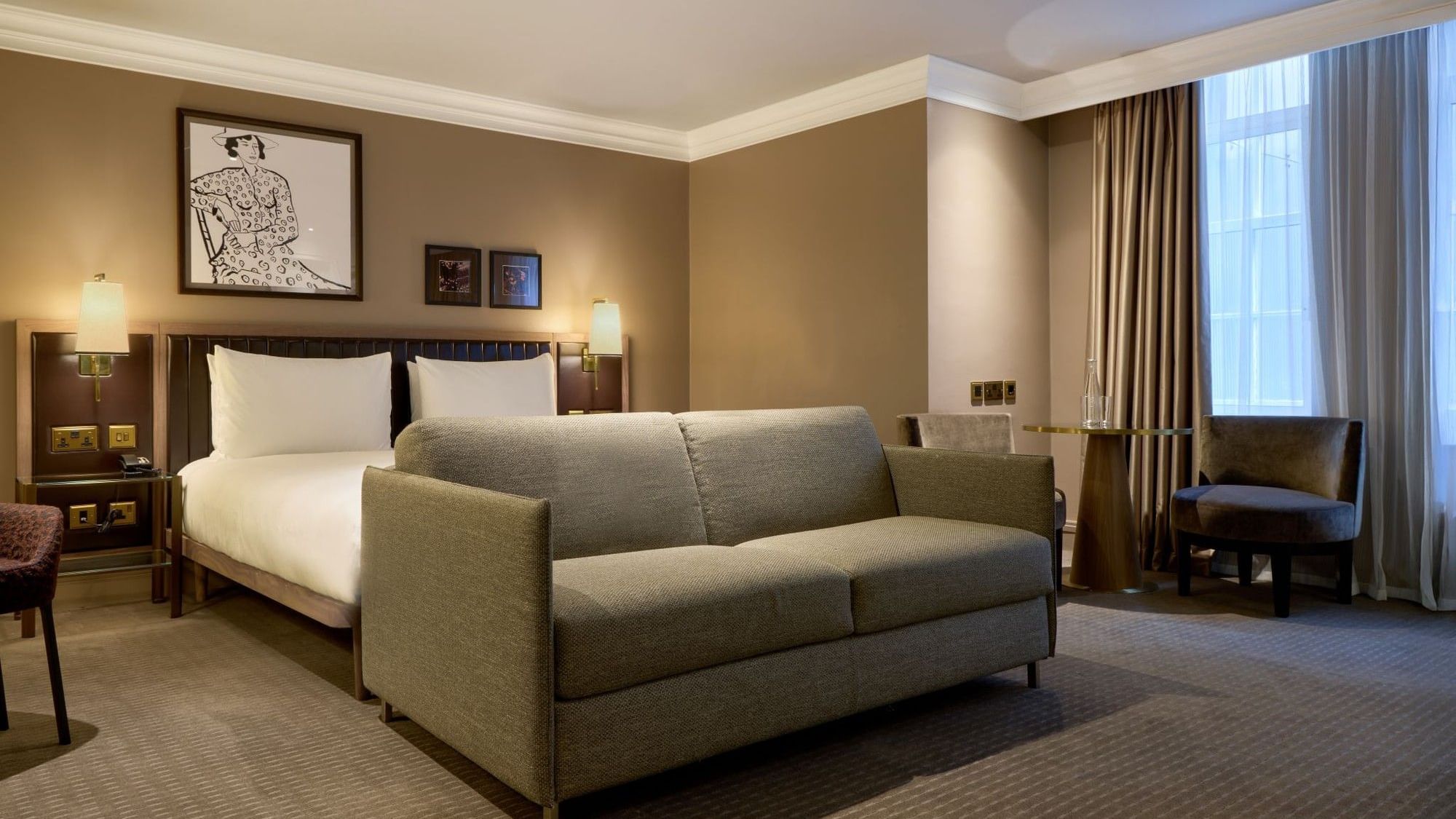 Elegant room with a large bed, couch, and chairs at The May Fair Hotel, London, England.