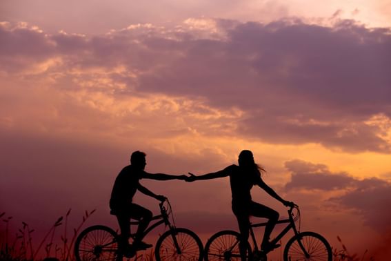 Couple riding bicycles at sunset, Tanjung Rhu Resort Langkawi