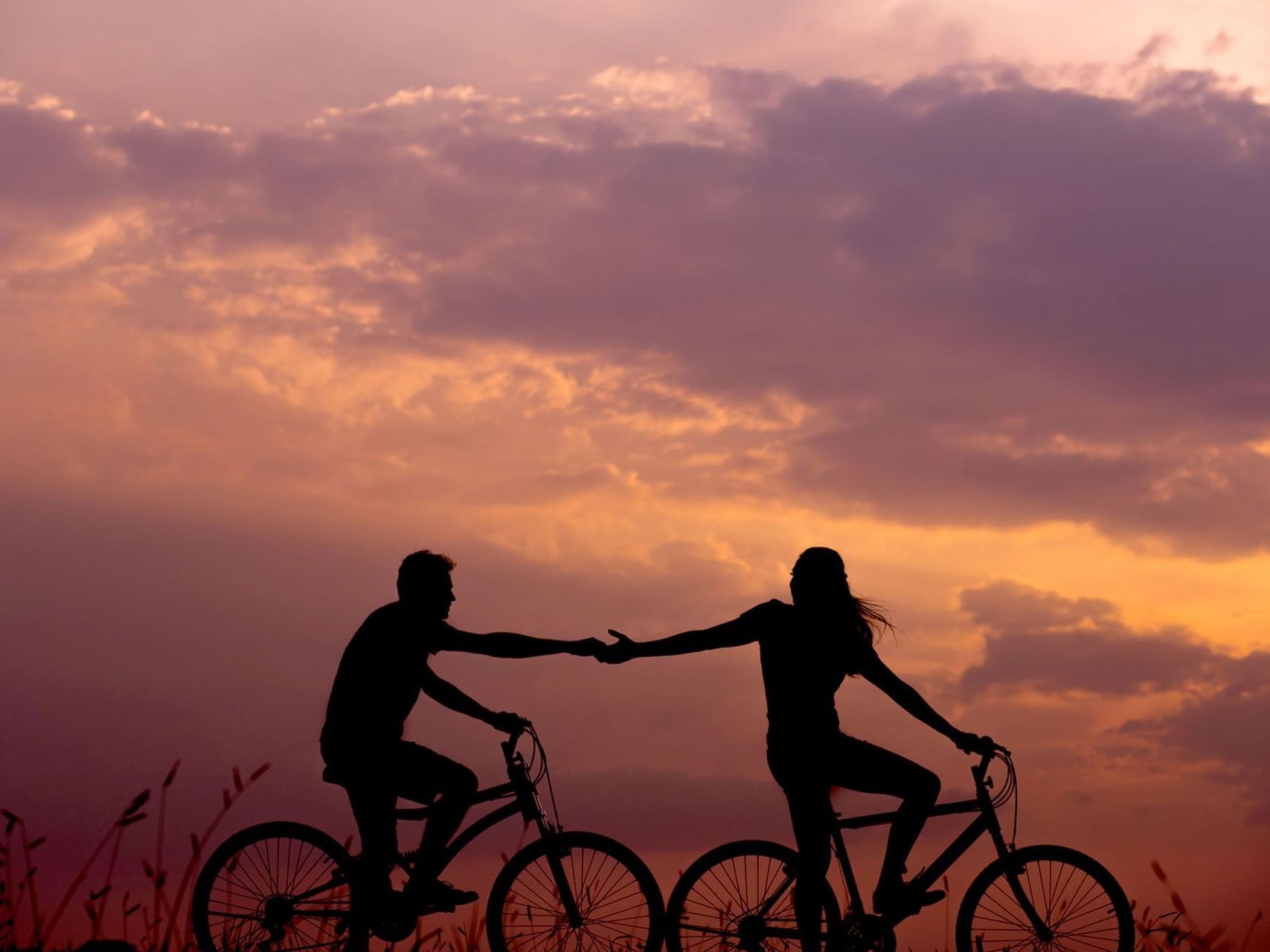 Couple riding bicycles at sunset, Tanjung Rhu Resort Langkawi