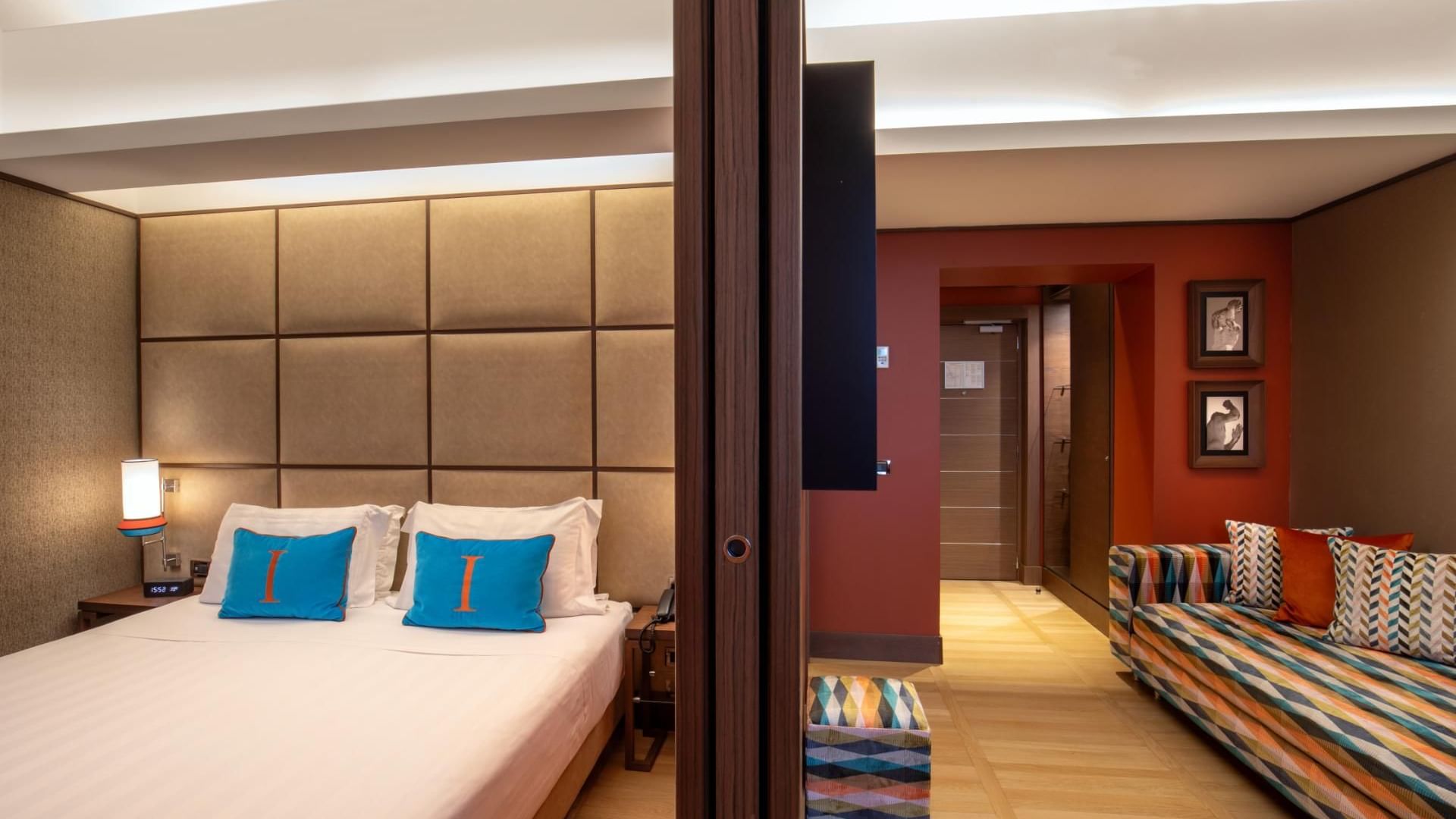Contemporary Junior Suite with colorful pillows, cozy seating, and warm lighting at The Independent