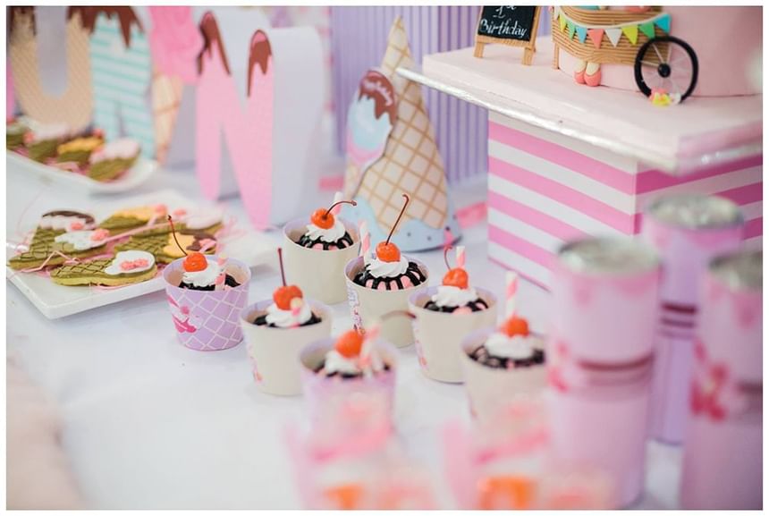Dessert table with cupcakes, ice cream treats, and a birthday cake, surrounded by playful decorations at Park Hyatt Saigon