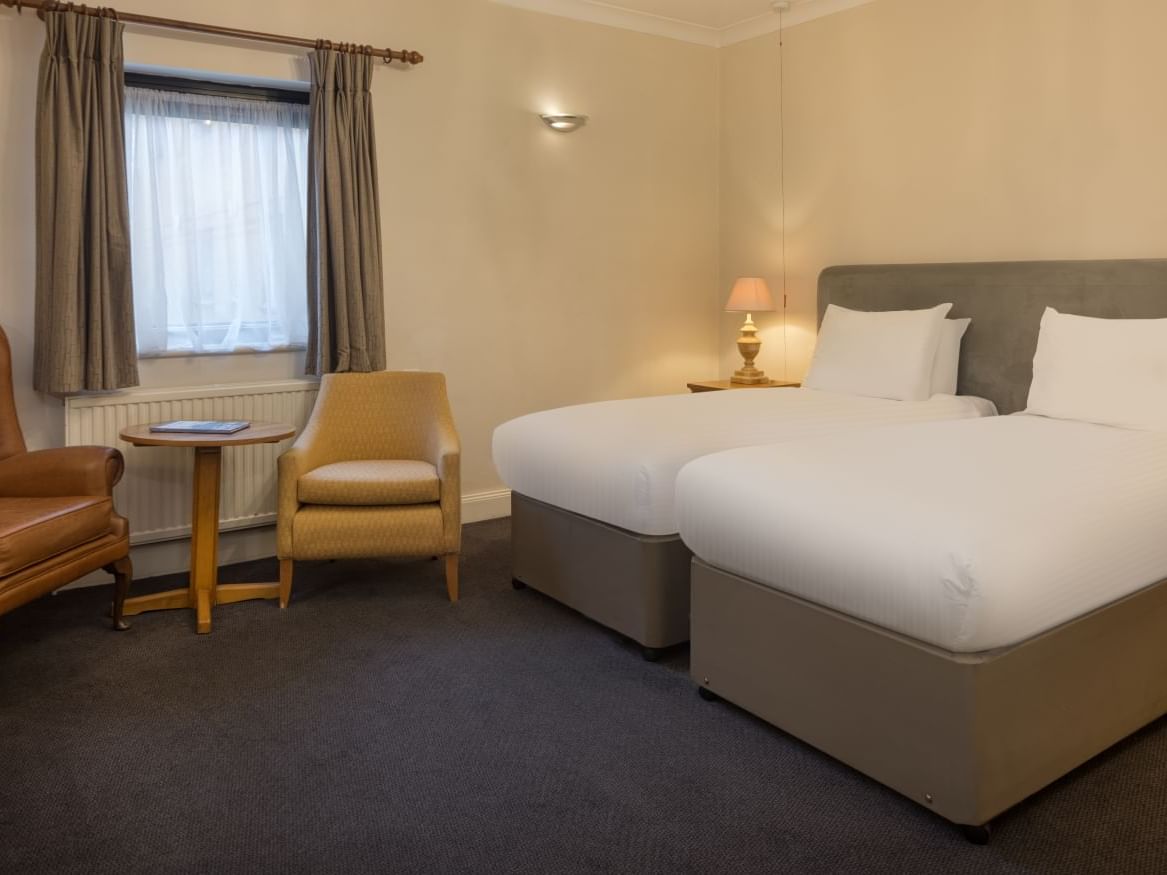 Twin beds, couches in Accessible Room at Bridgewood Manor Hotel