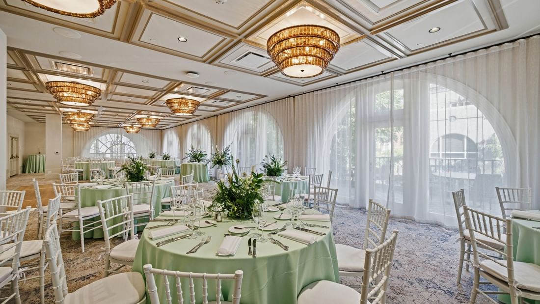 Elaborately set dining tables and chairs in La Terraza Ballroom at el PRADO Hotel in Palo Alto.
