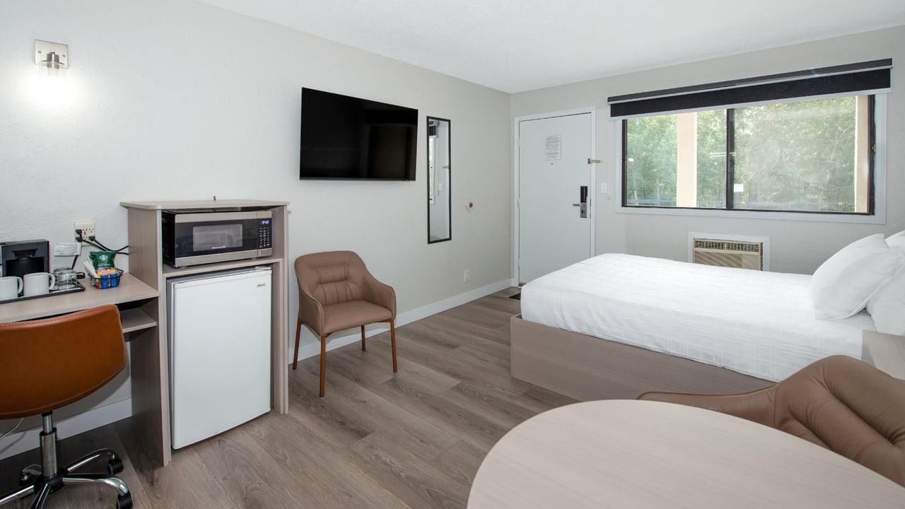 Guest room at Coast Red Deer Hotel with queen bed, desk and seating area