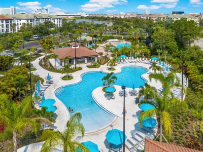 Aerial view of a pool with lounge chairs and umbrellas at Vista Cay Resort By Millenium