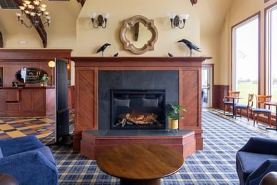 Cozy lobby seating area by a large fireplace at the luxury accommodations pei Rodd Crowbush Golf Resort