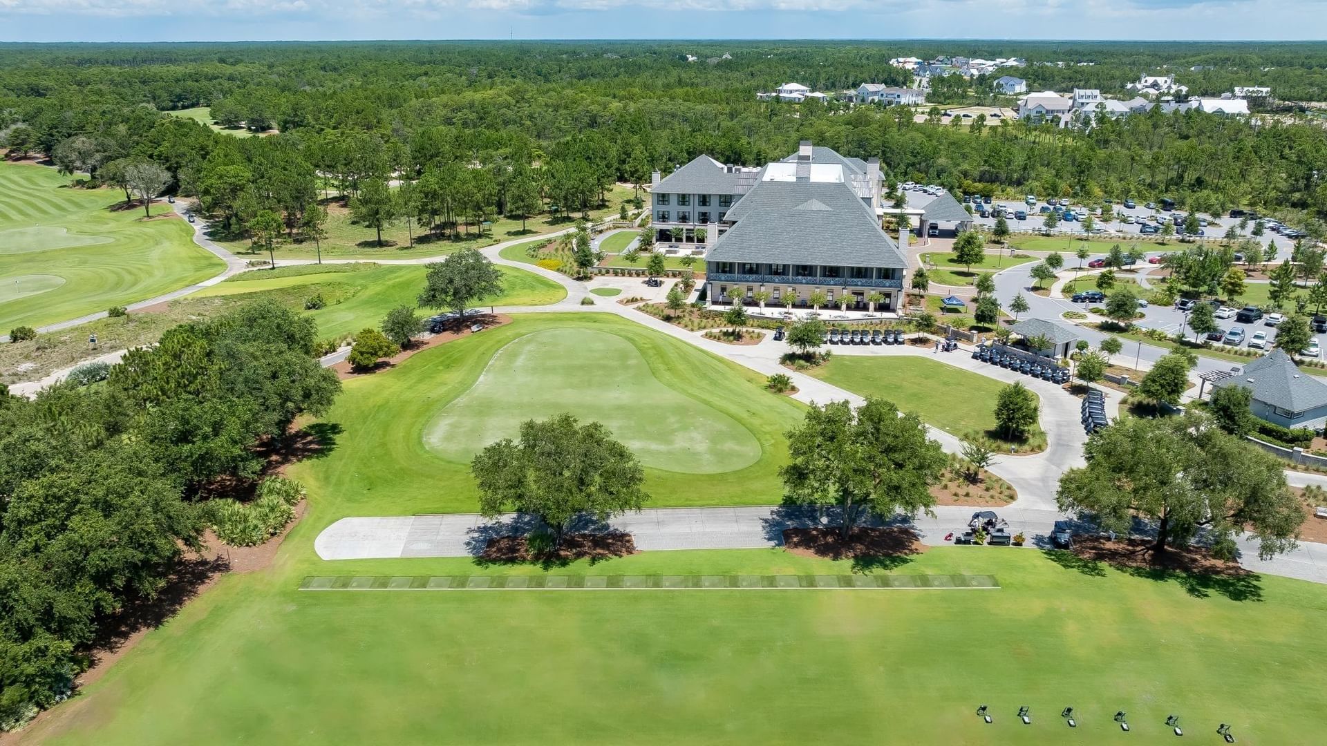 Aerial view of Camp Creek Driving Range with manicured greens, clubhouse, and golfers practicing at Camp Creek Inn.