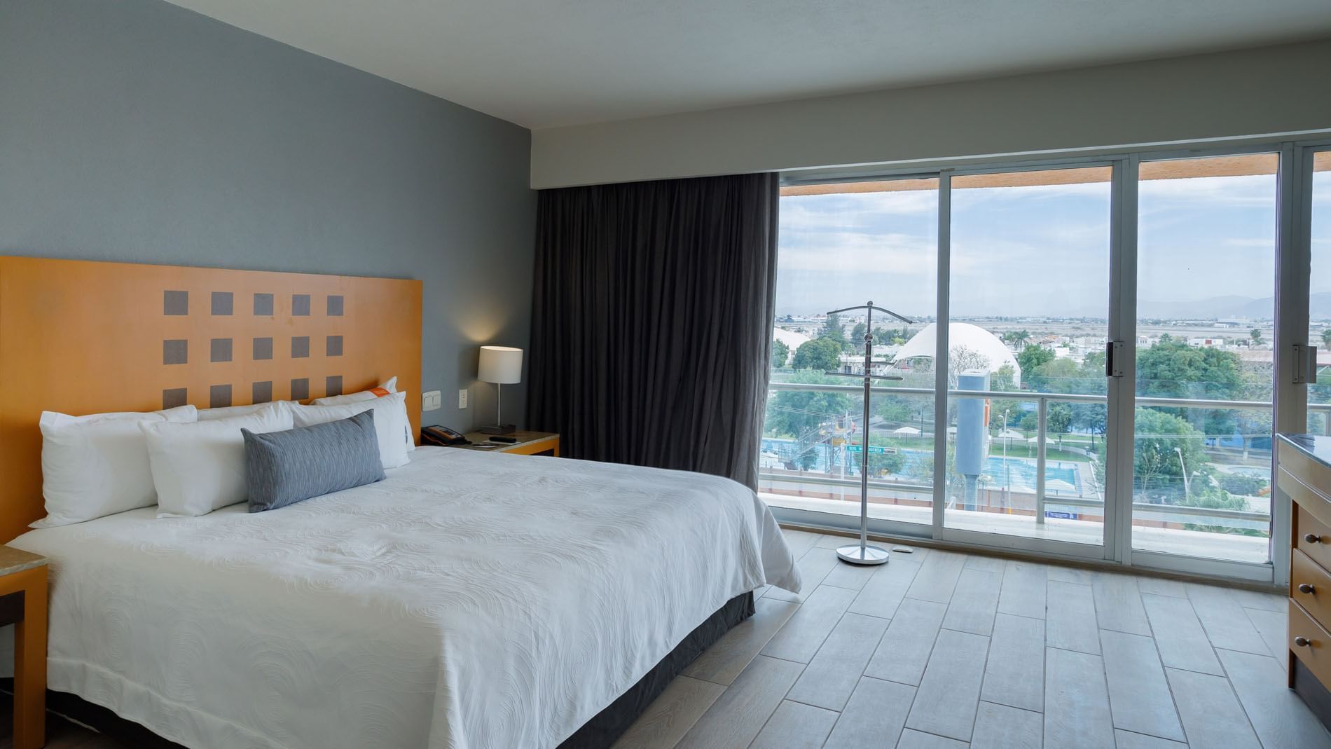Sunny King Master Suite with floor-to-ceiling glass doors leading to a private outdoor terrace at Real Inn Torreon