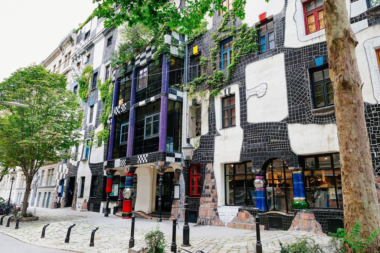 Hundertwasserhaus in Vienna with colorful facade, irregular shapes and green window details
