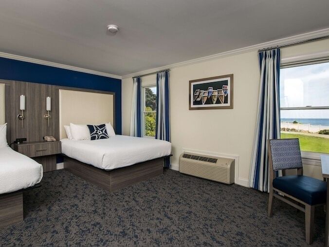 Workspace & nightstand by the beds in Double Queen Ocean View Room at Union Bluff Hotel