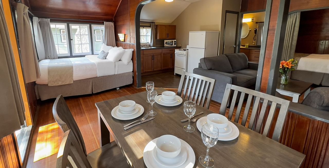 Interior of cabin with dining area, bed, sitting area, and kitchen