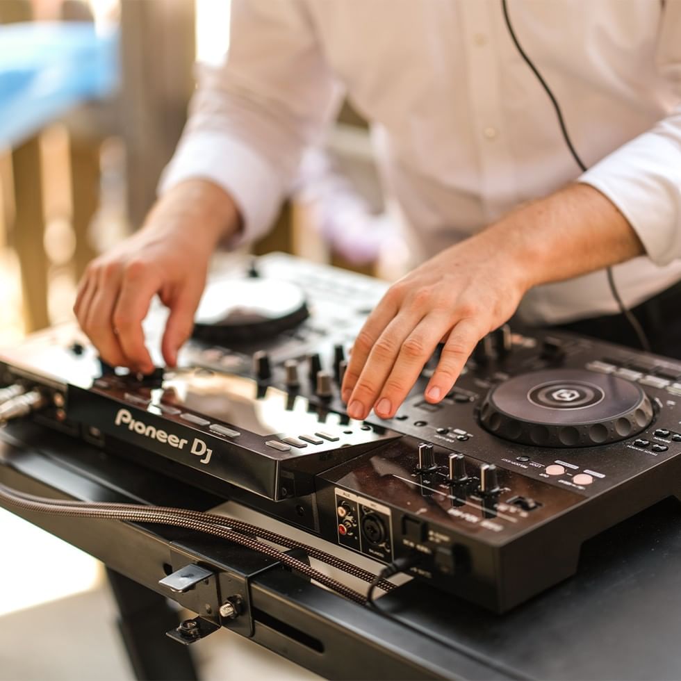 DJ using a Pioneer DJ mixer for an event.