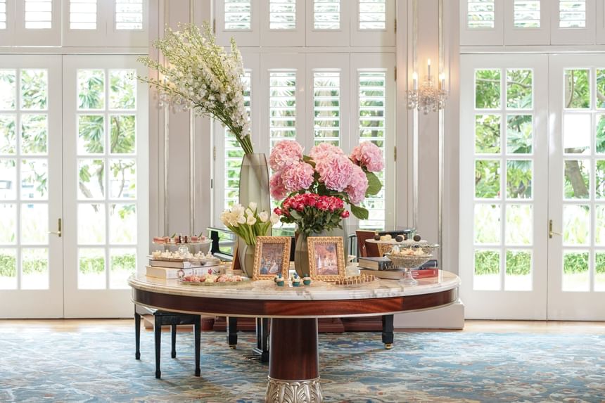 Floral dessert setup with framed photos and soft light in Park Lounge at Park Hyatt Saigon